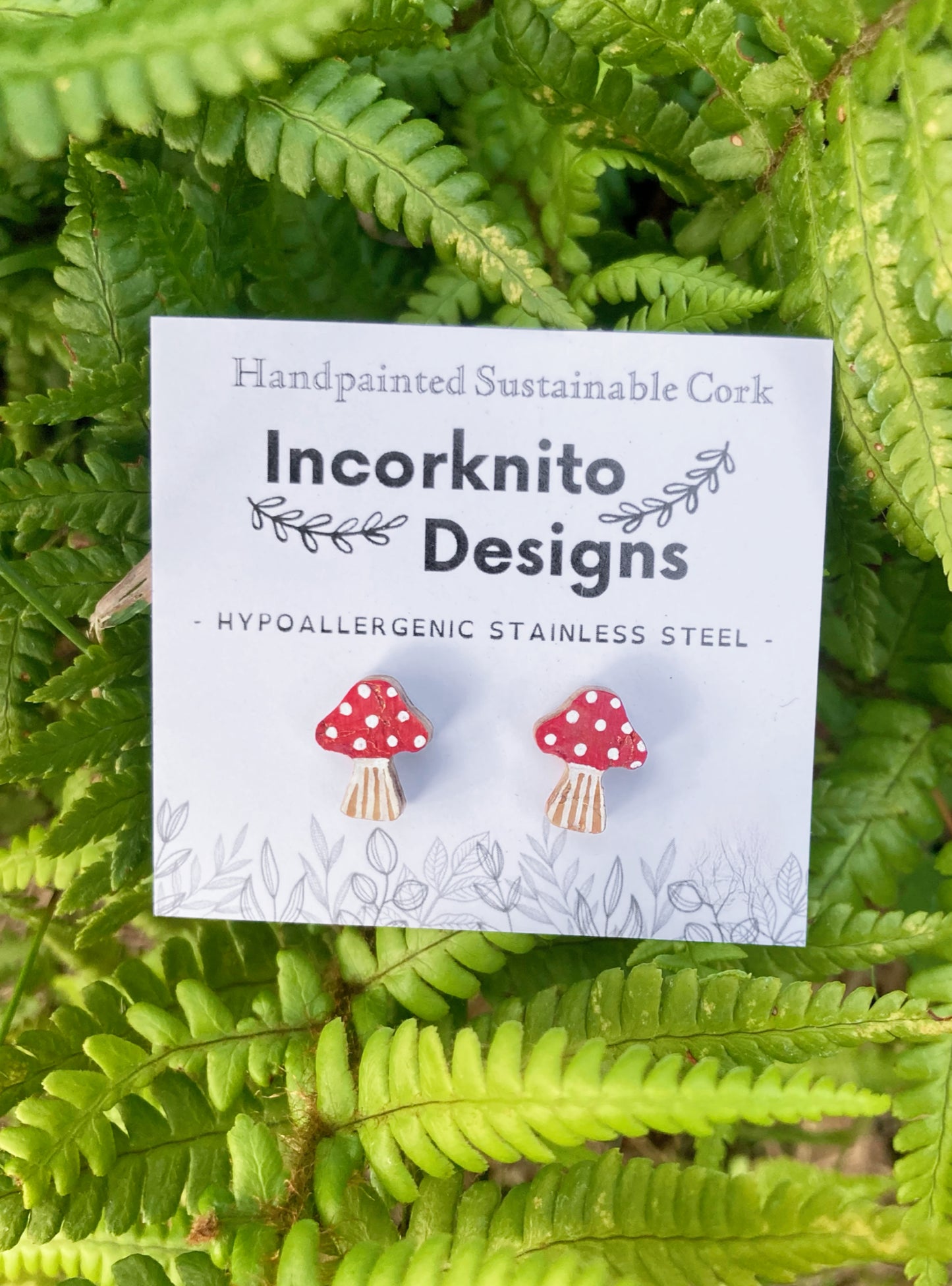 Incorknito Designs packaging with mushroom earrings on a green leaf background