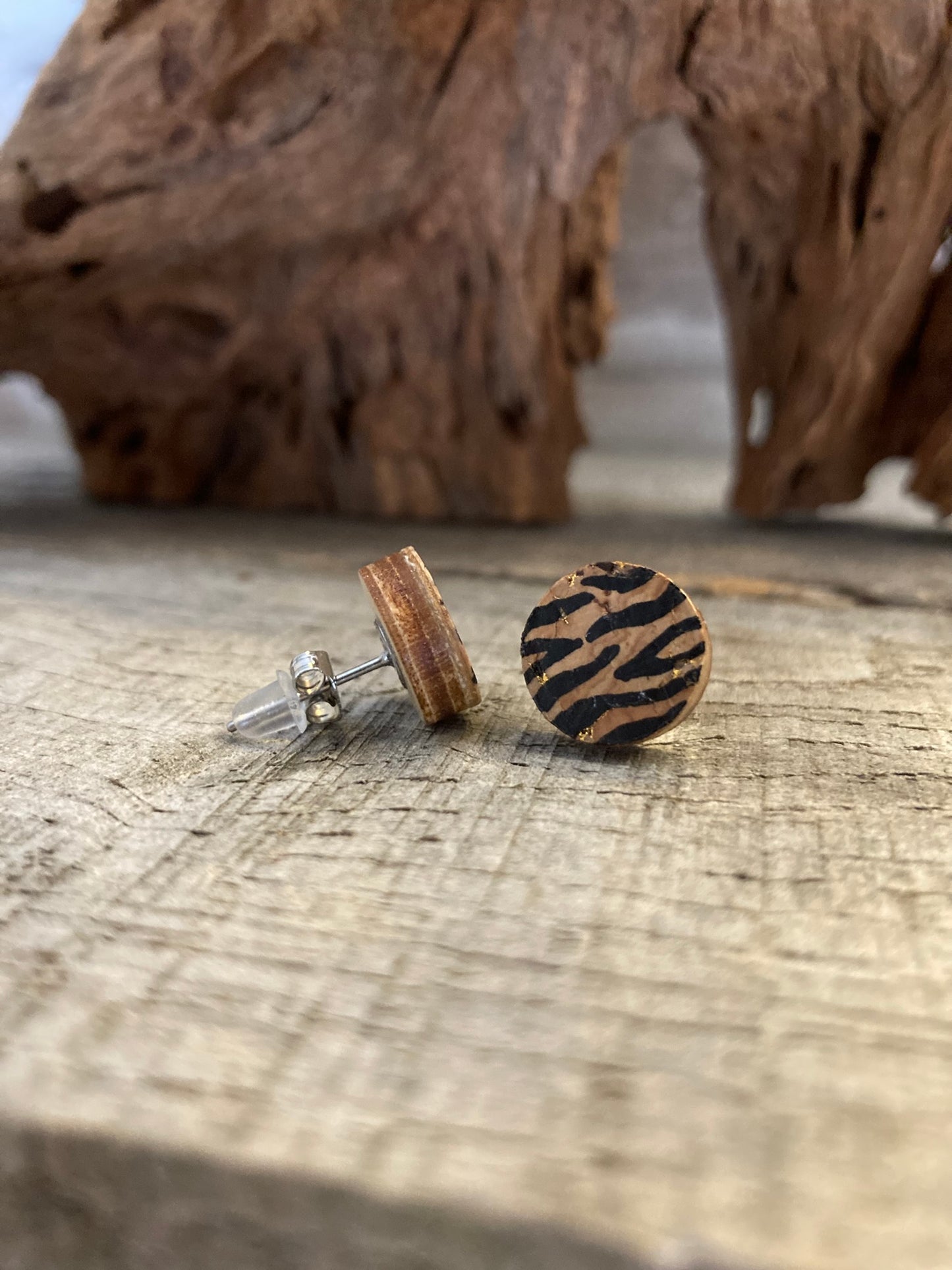 A pair of tiger print studs fastened with a metal butterfly back and rubber one