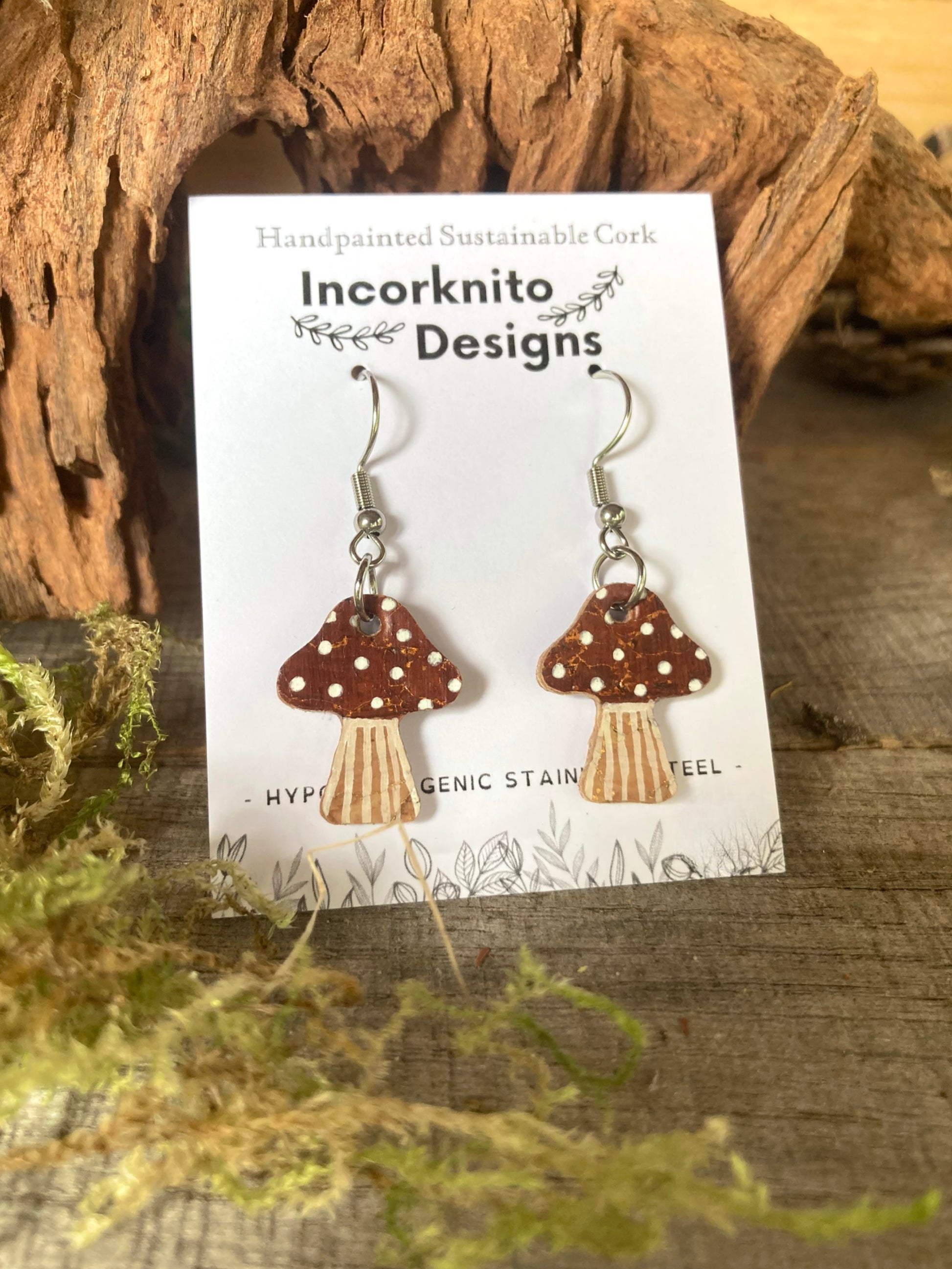 Mushroom-shaped earrings on a 'Incorknito Designs' card with natural background
