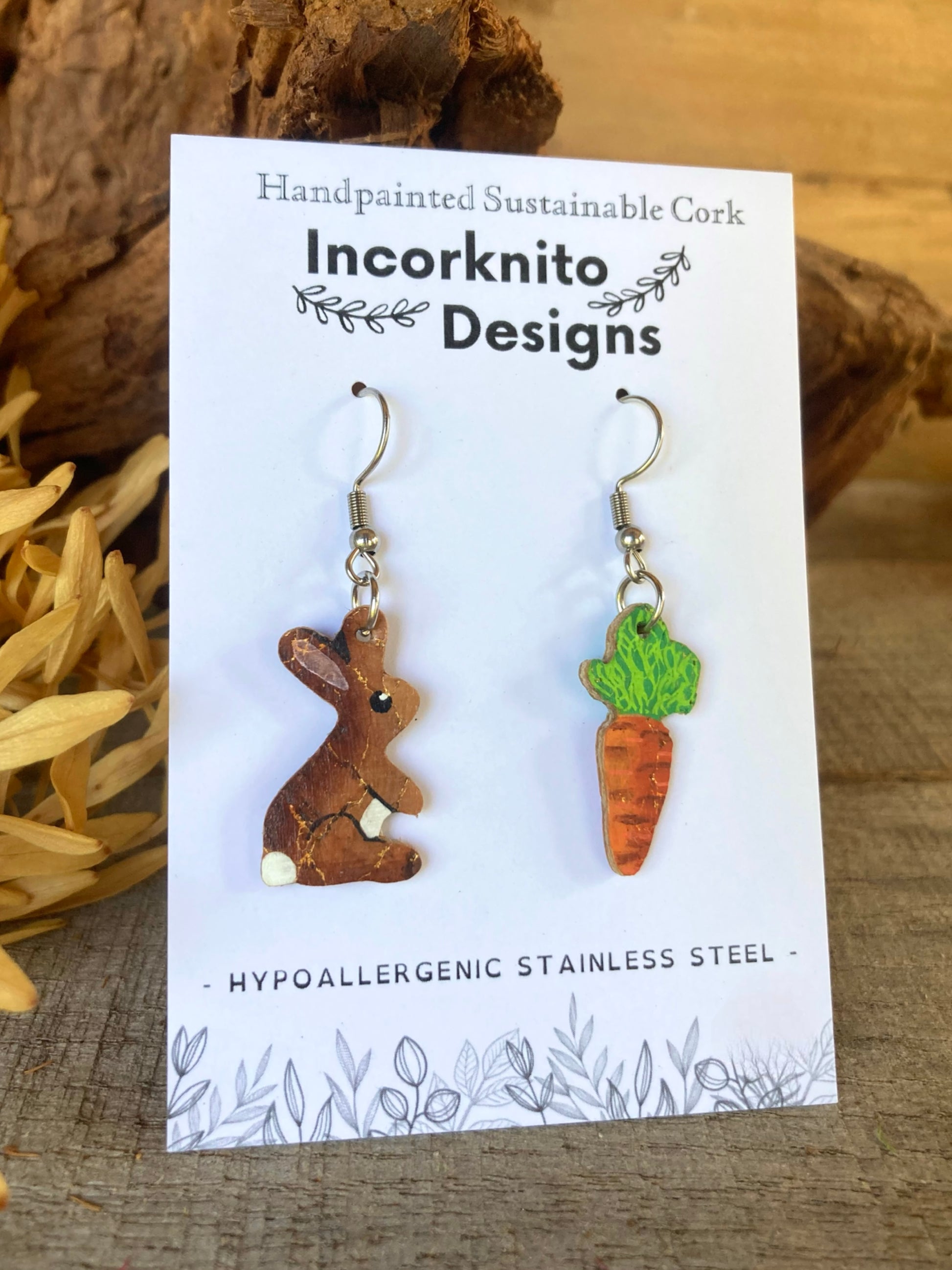 Pair of cork bunny and carrot earrings on a 'Incorknito Designs' card with natural background.
