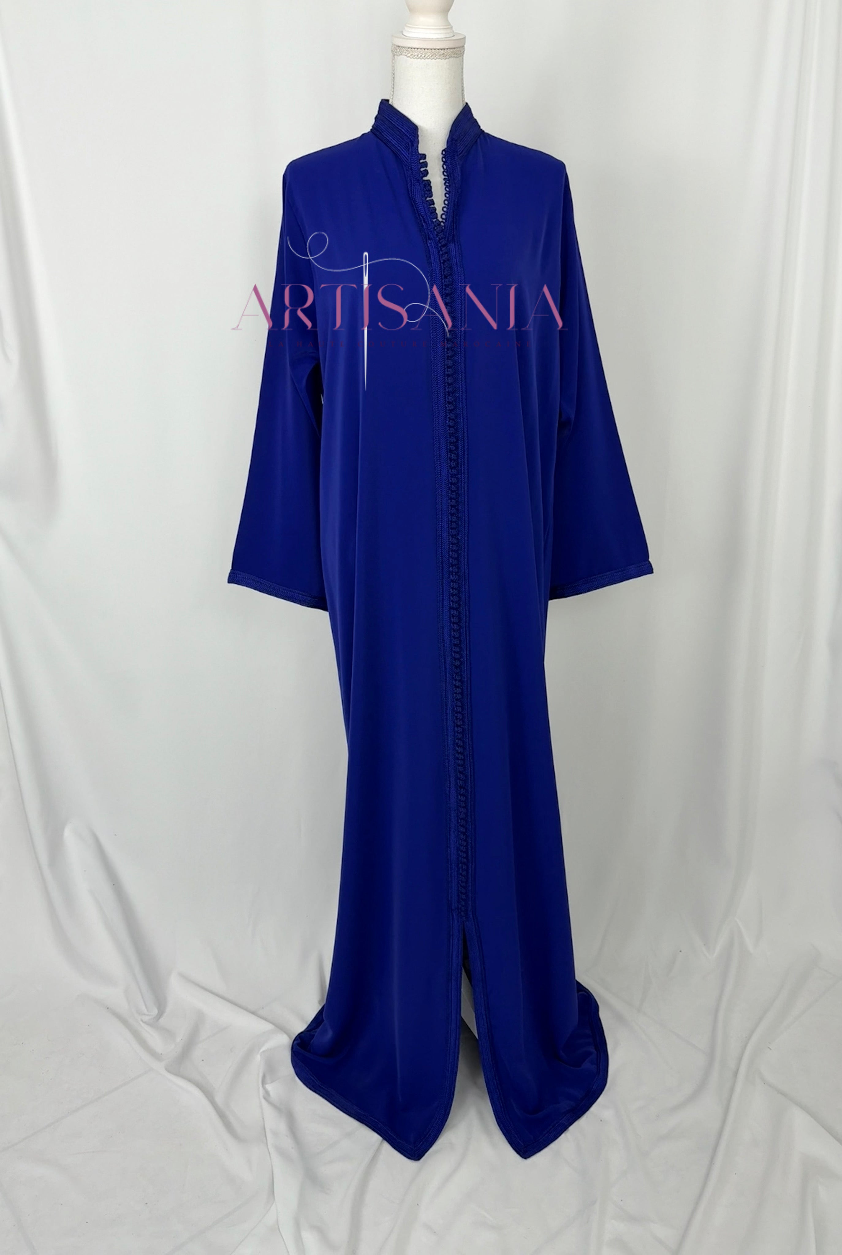 Blue and orange bird-shaped earrings on a wooden surface with grass.