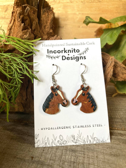Bay and brown horse cork earrings on silver hooks on Incorknito Designs branded card against natural wood and greenery — handpainted sustainable cork jewellery