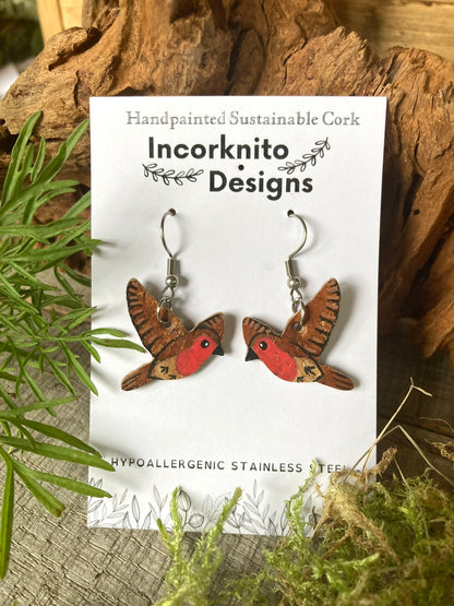 Flying robin cork earrings on silver hooks on Incorknito Designs branded card with cork and moss background. Eco-friendly nature jewellery, handpainted in Suffolk, UK.