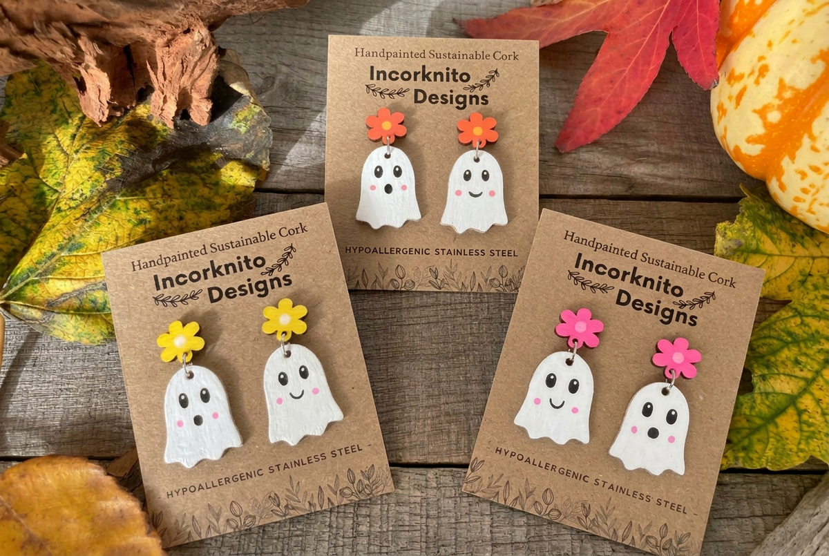 Three pairs of white cork ghost earrings with yellow, orange and pink flower stud tops, displayed among autumn leaves.

