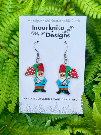 Gnome with toadstool cork earrings on silver hooks on Incorknito Designs branded card against lush green ferns — handpainted sustainable jewellery