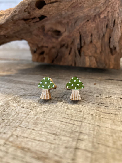 Green toadstool cork stud earrings with white polka dots — close-up detail