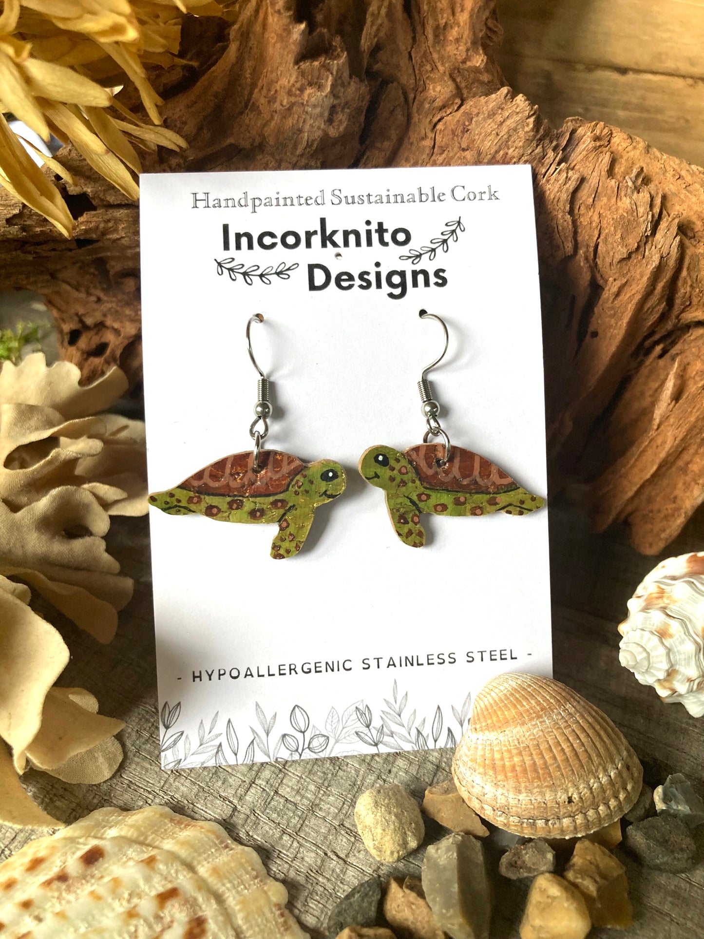 Green sea turtle earrings on silver hooks, handpainted on sustainable cork with gold flecks, on a natural background