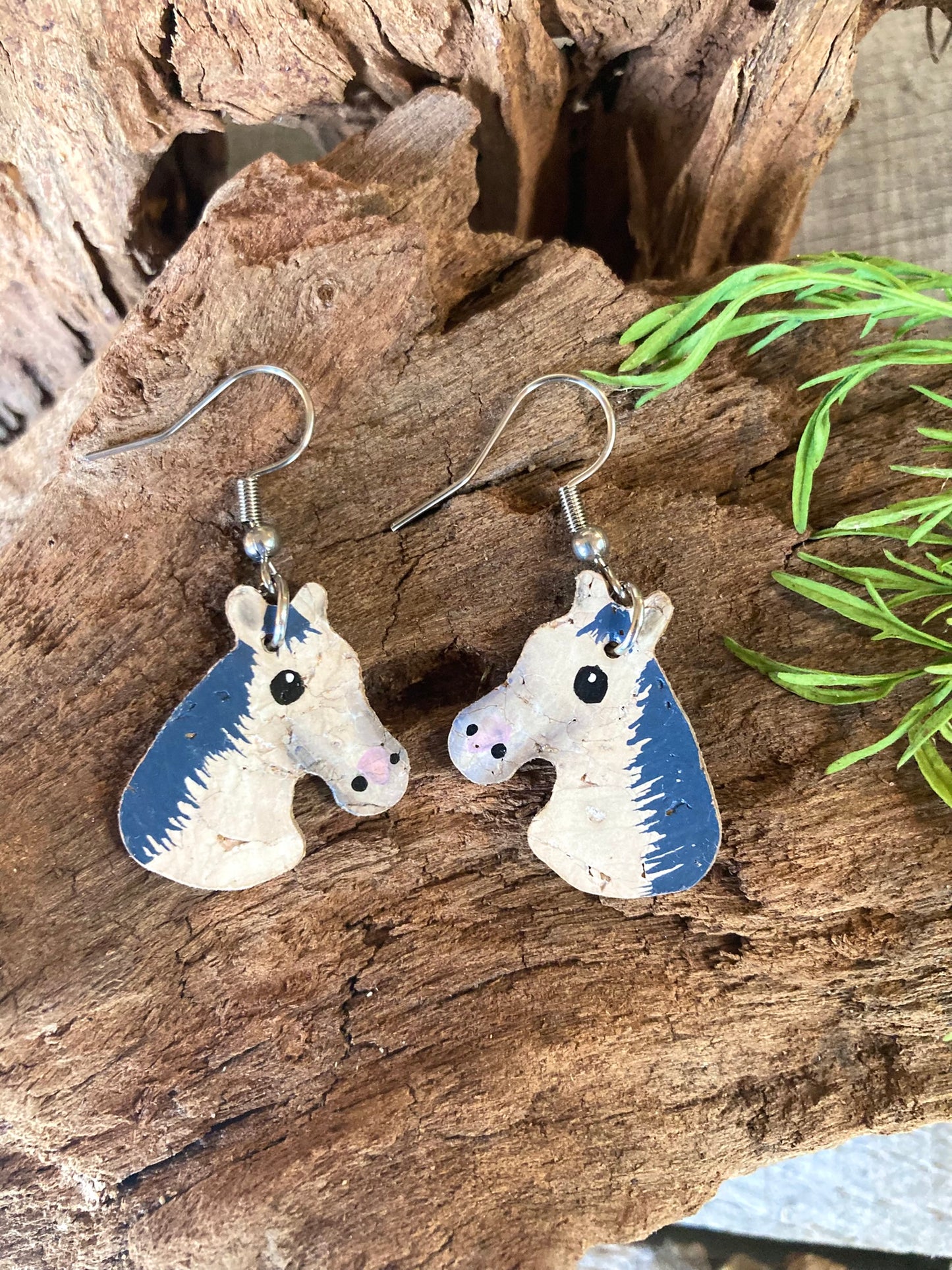Grey and white horse cork earrings on silver hooks on Incorknito Designs card against natural greenery — handpainted equestrian jewellery handmade in UK
