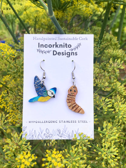 Incorknito Designs mismatched blue tit earrings on white card with yellow garden flowers