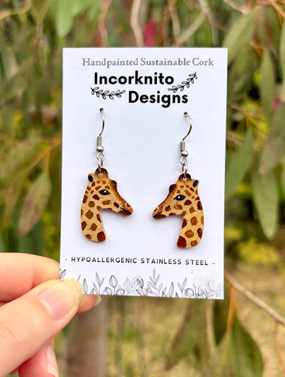 Handpainted Giraffe cork earrings displayed on an earring card