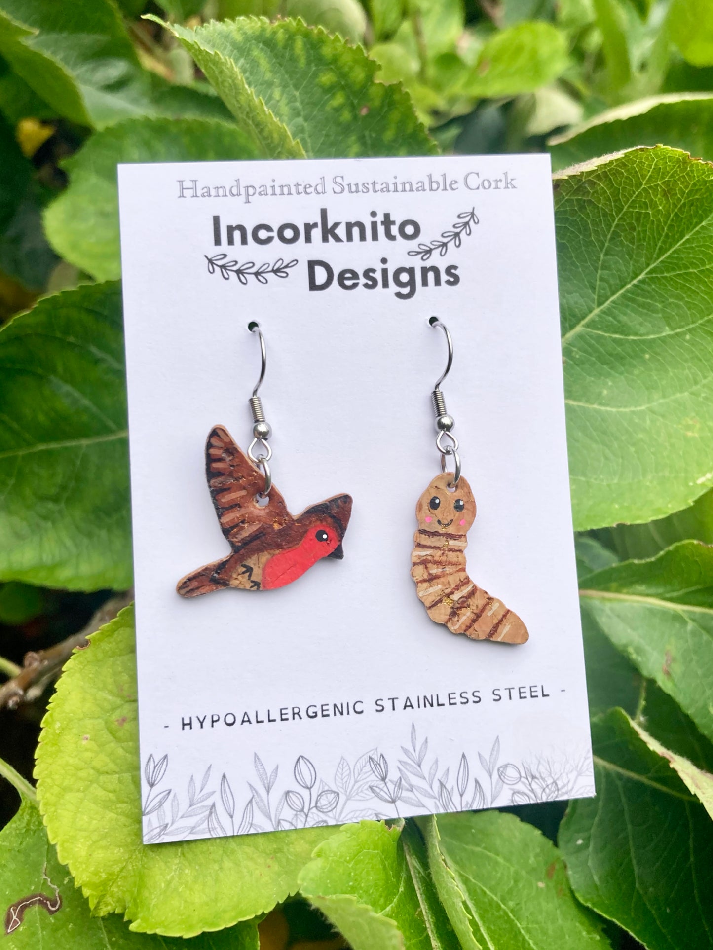Mismatched handpainted robin and worm cork earrings on Incorknito Designs branded card — eco-friendly bird jewellery handmade in Suffolk UK