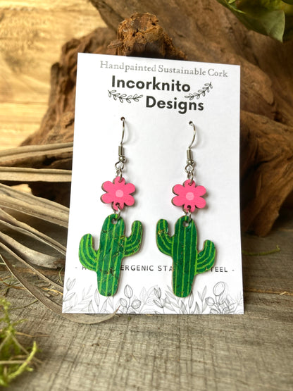 Cacti flower hook earrings in pink on an Incorknito Designs card, propped against cork bark with driftwood background