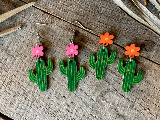 Cacti flower stud drop earrings in pink and orange, both colourways flat lay on weathered wood