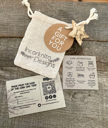 Incorknito Designs branded hessian gift bag with kraft "A Gift For You" tag, bark star charm, care card and cork about card laid out on weathered wood