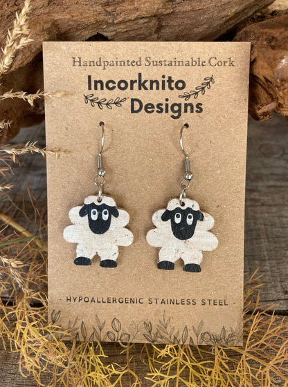 Handpainted cork sheep earrings on silver hooks, displayed on Incorknito Designs branded card with cork bark and dried grass background