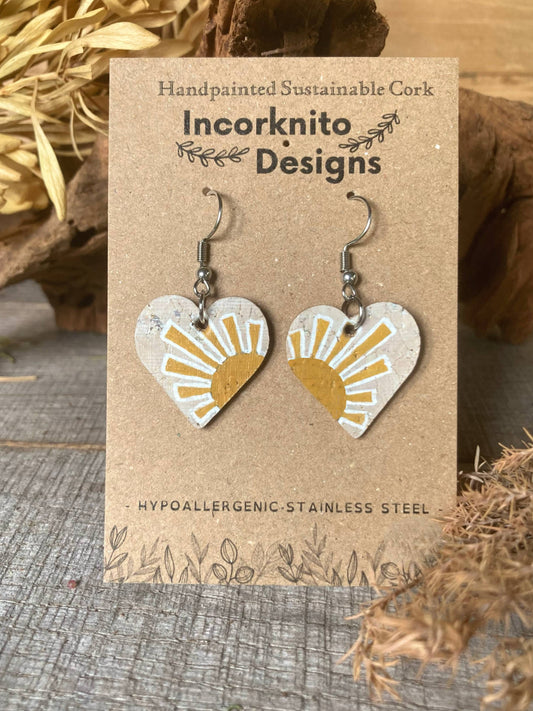 Handpainted yellow sun heart cork earrings on silver hooks, displayed on Incorknito Designs branded card with cork bark and dried grass background