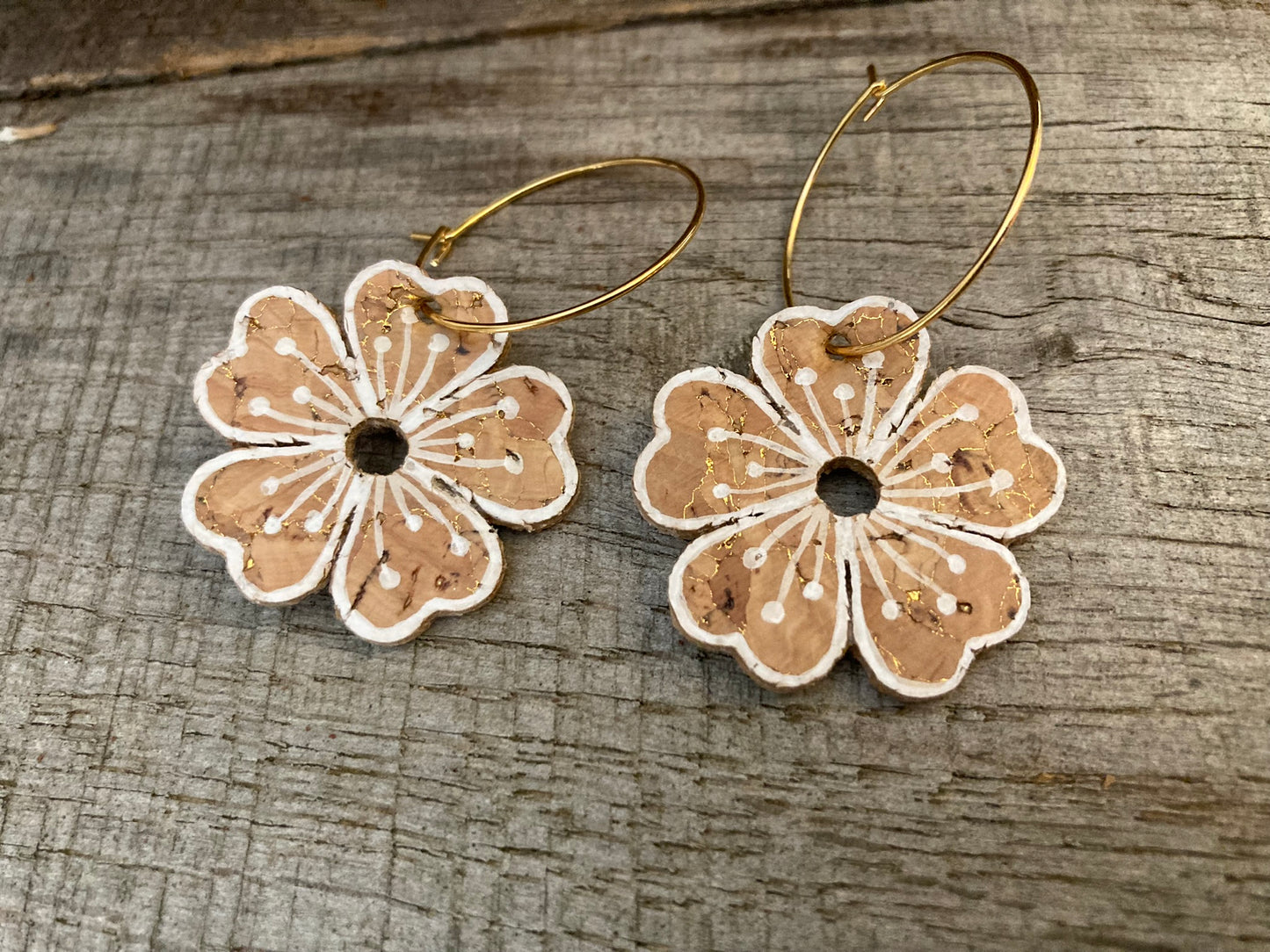Natural large flower cork hoop earrings close-up flat lay — gold hoops showing the gold fleck cork texture and handpainted white pollen detail