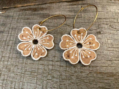 Natural large flower cork hoop earrings close-up flat lay — gold hoops showing the gold fleck cork texture and handpainted white pollen detail