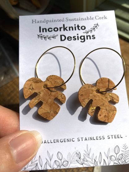 Natural cork monstera earrings on gold hoops on Incorknito Designs branded card — hypoallergenic stainless steel sustainable cork jewellery