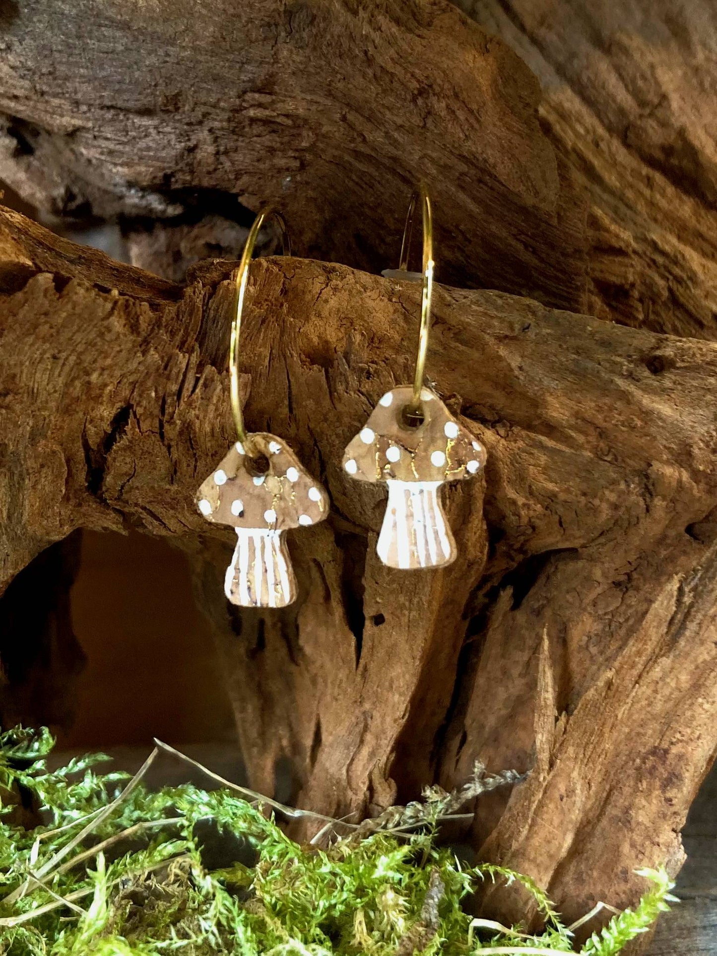 Natural beige toadstool cork mini hoop earrings nestled in a driftwood hollow with moss — handpainted sustainable earrings 