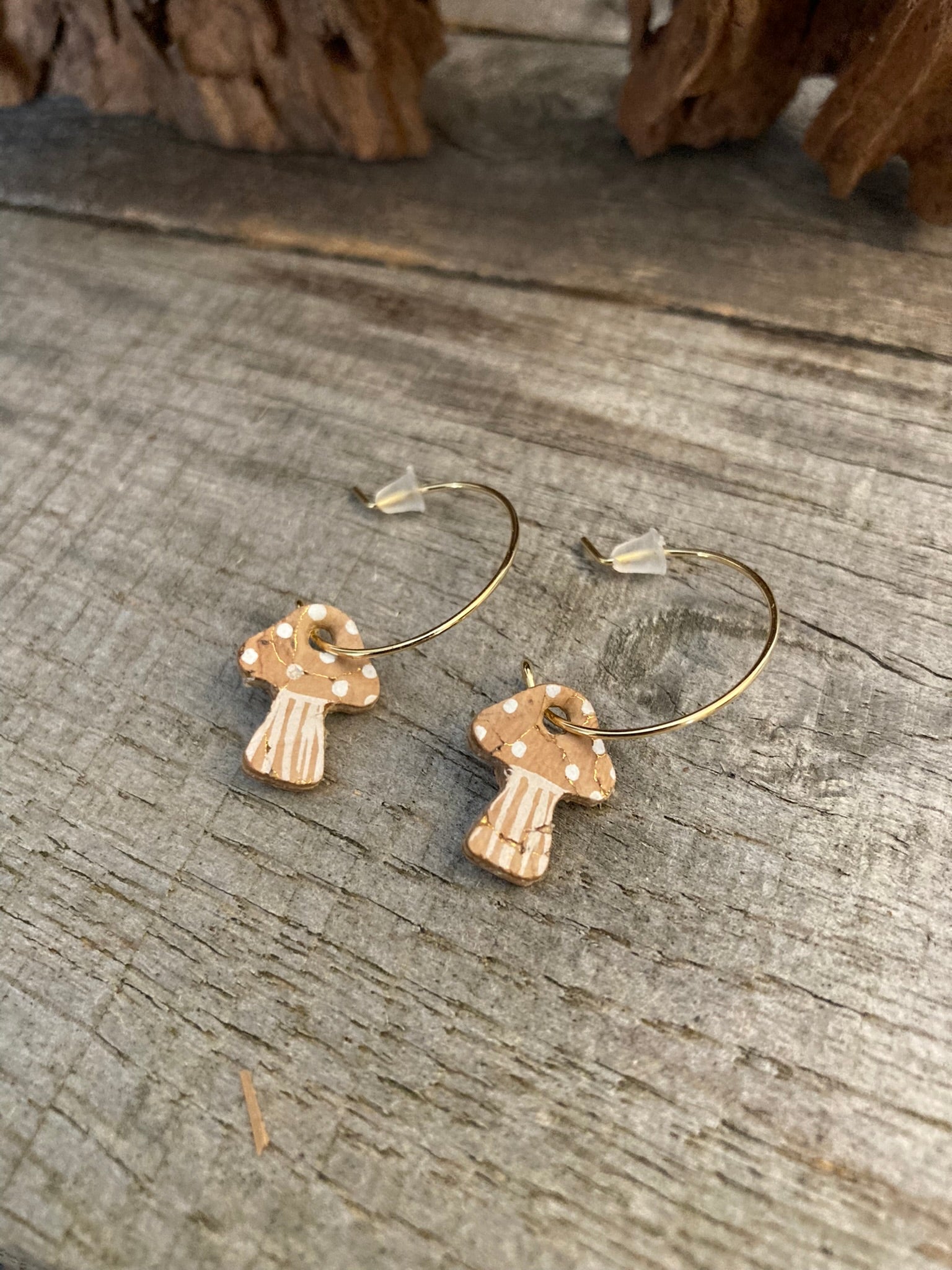 Natural beige toadstool cork mini hoop earrings flat lay on weathered wood — white spot detail on a natural cork cap with striped stem