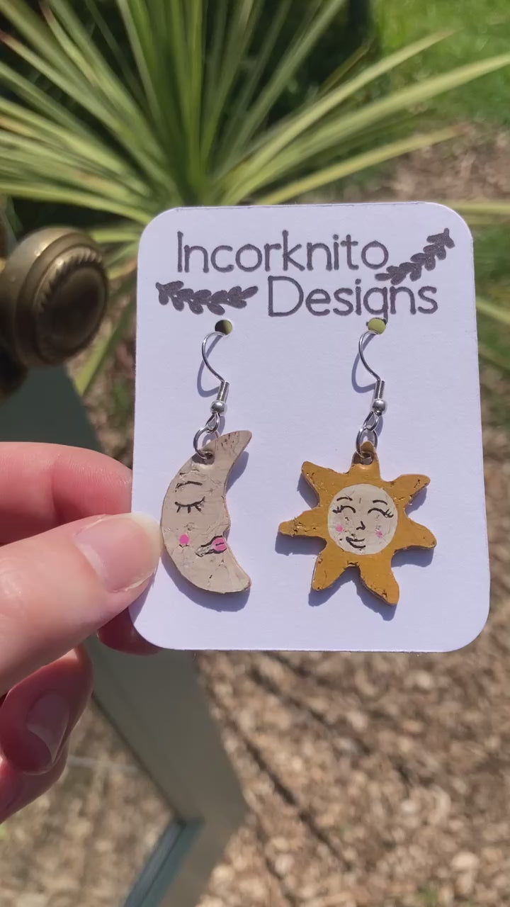 Video depicting our smiley sun and moon earrings in the sunshine. Gold flecks glimmering the sunlight