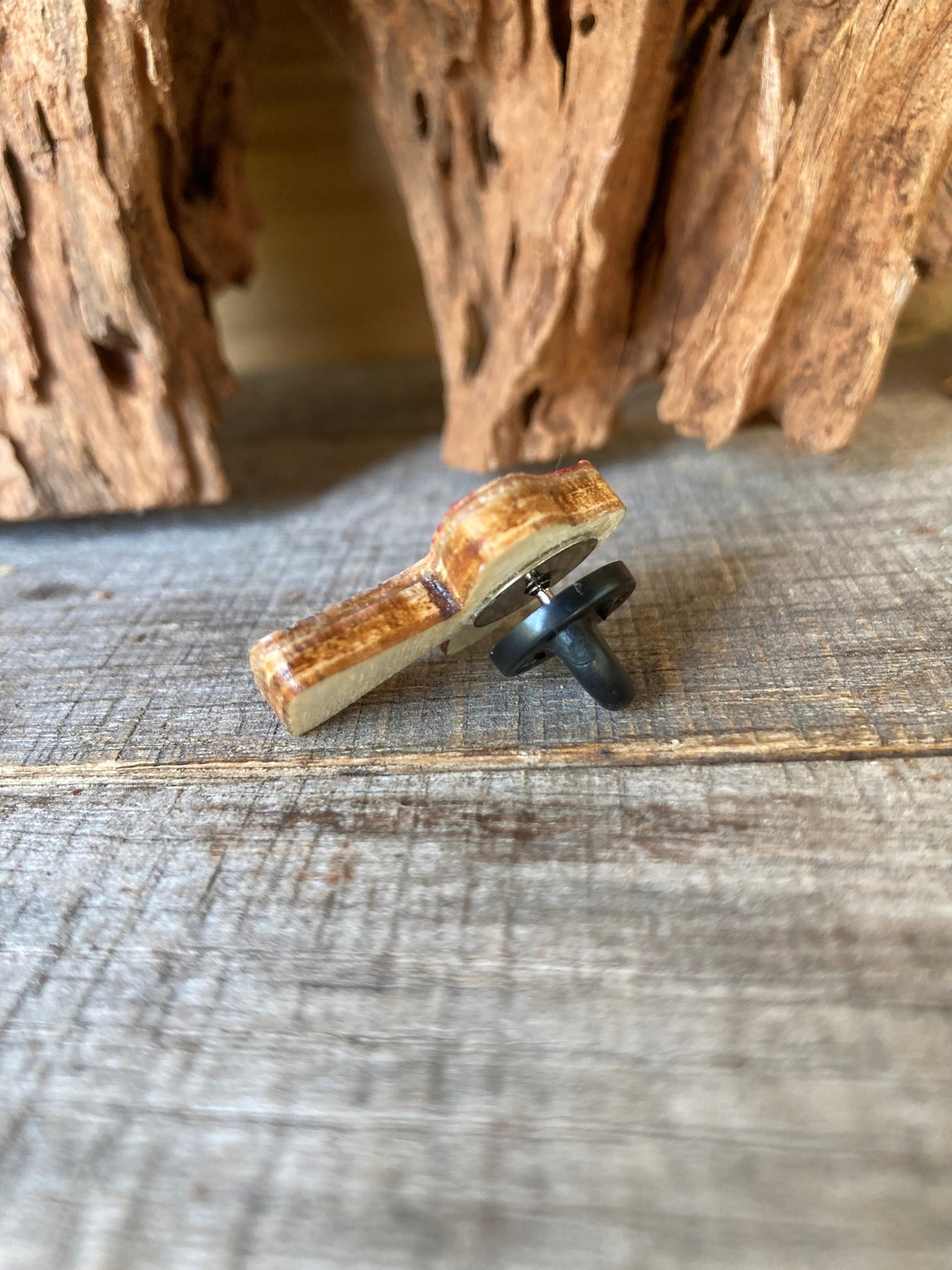 Reverse of the red toadstool cork pin badge showing FSC-certified ply base and black rubber pin back — secured and finished for everyday wear