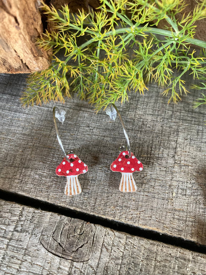 Red toadstool cork mini hoop earrings on weathered wood with wild fennel and driftwood — fly agaric design with white spot detail