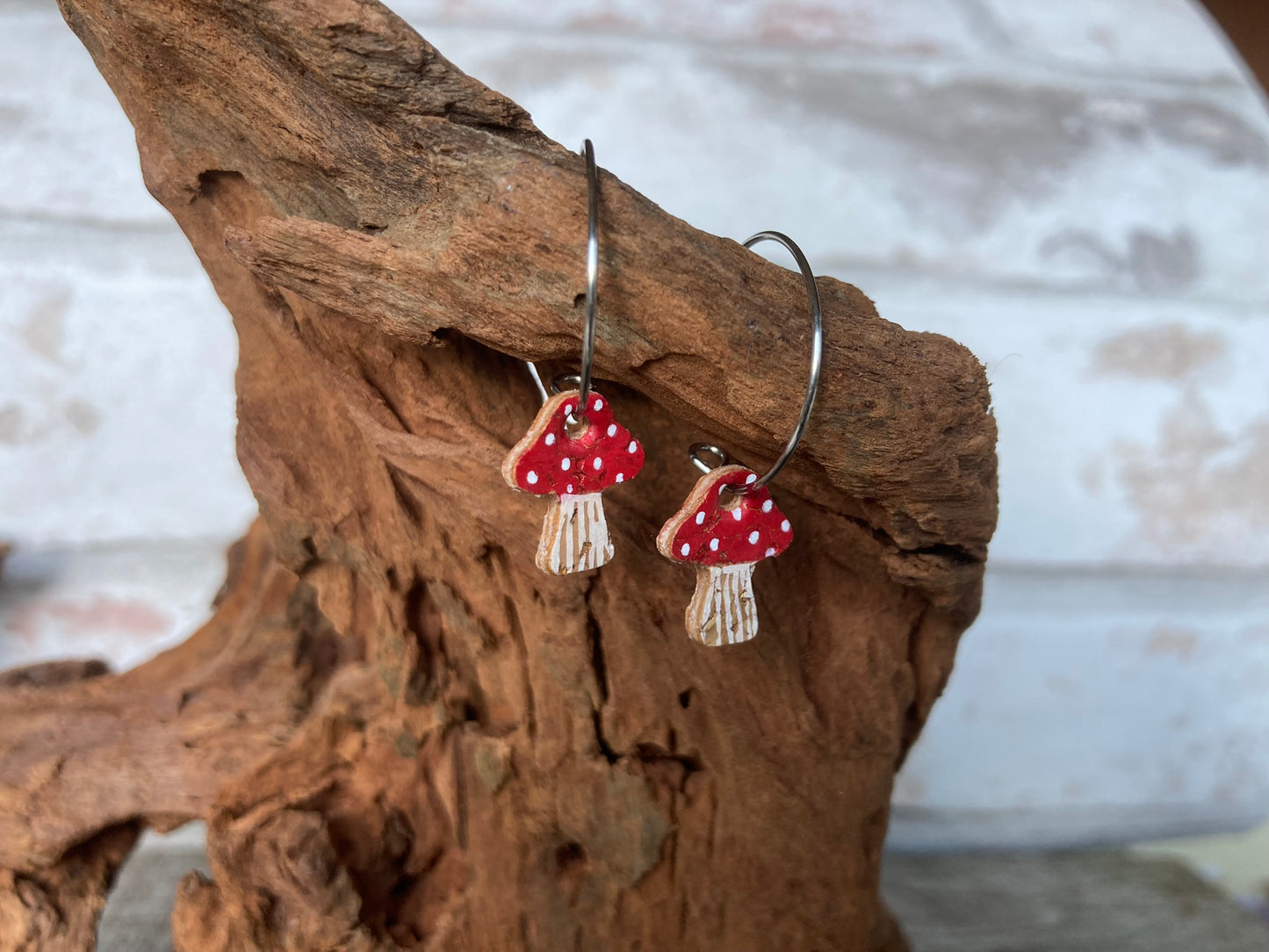 Side profile of red toadstool cork mini hoop earrings showing the FSC ply layers and stainless steel open hoop