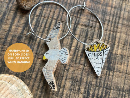 Infographic showing the reverse of seagull and chips cork earrings on silver hoops — handpainted on both sides for a full finish from every angle