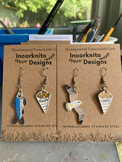 Two pairs of handpainted cork earrings — seagull and chips and fish and chips — showing the range of coastal and seaside designs by Incorknito Designs