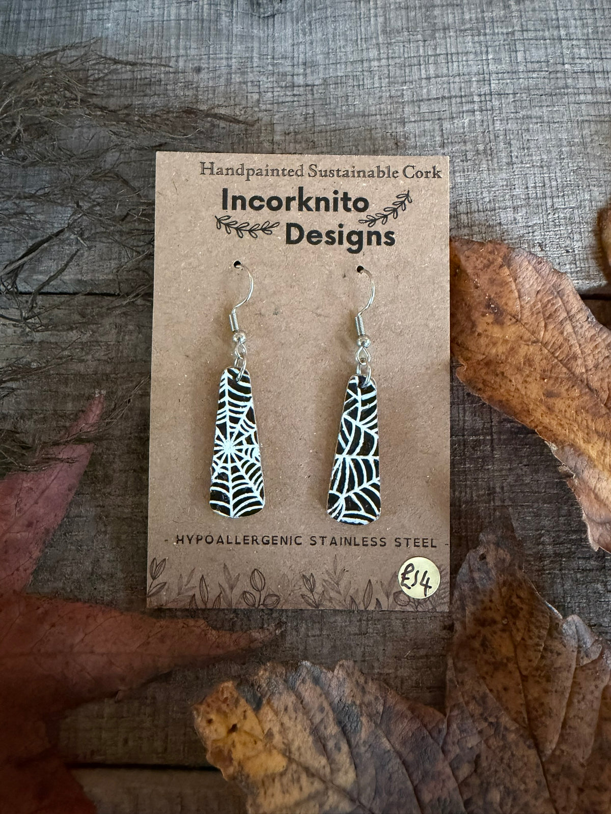  SW5 slim tapered cork earrings with silver hooks and delicate white cobweb lines on black, displayed on an Incorknito Designs card.