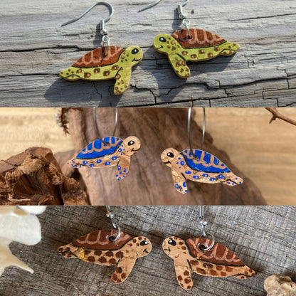 Three pairs of handpainted cork sea turtle earrings in blue, green and brown — all colourways shown together in a coastal natural setting collage