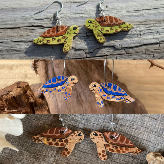 Three pairs of handpainted cork sea turtle earrings in blue, green and brown — all colourways shown together in a coastal natural setting collage